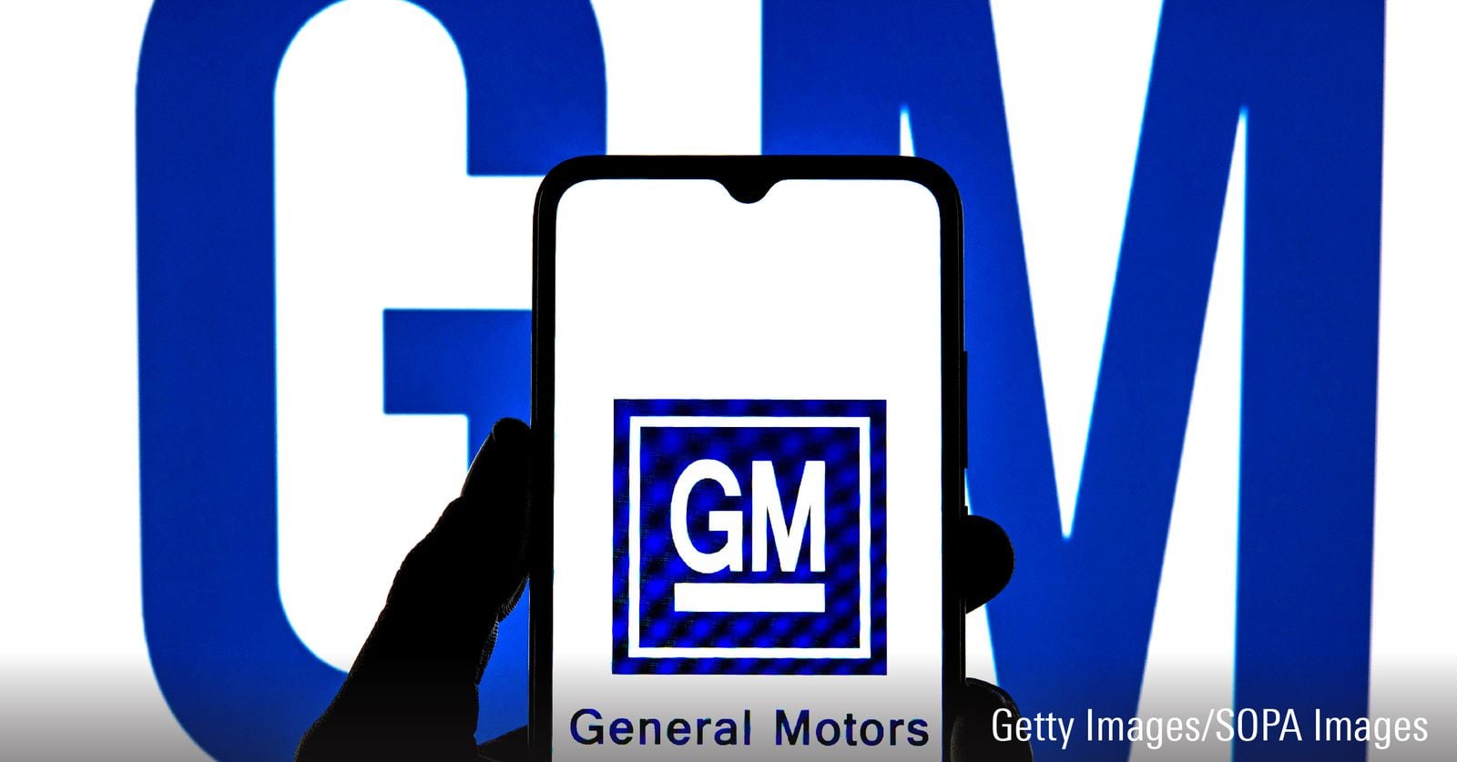 In this photo illustration a General Motors Company logo seen displayed on a smartphone with a General Motors Company logo in the background.