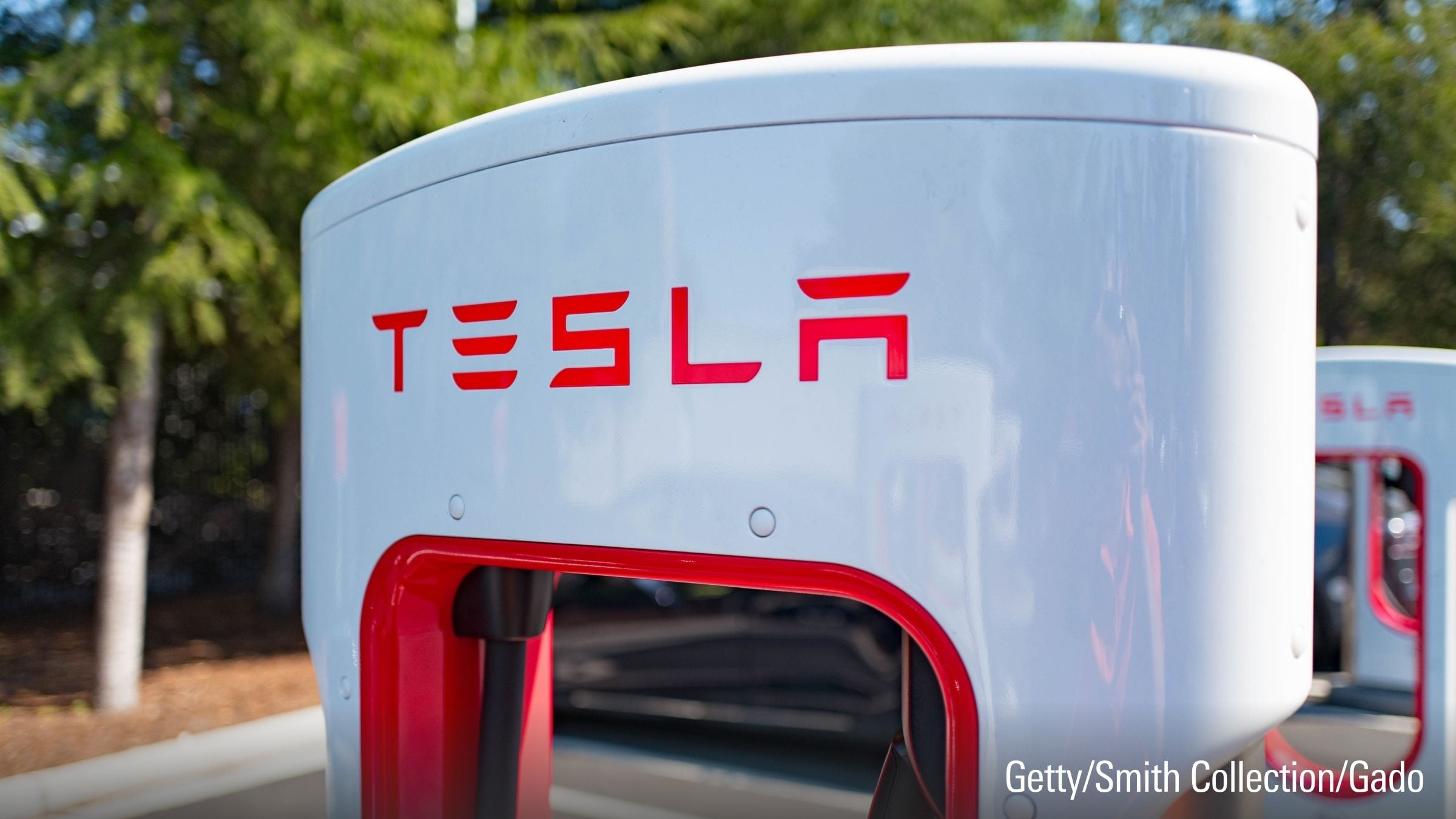 Ladegerät mit Tesla-Logo an einer Supercharger-Schnellladestation für das Elektrofahrzeugunternehmen Tesla Motors.