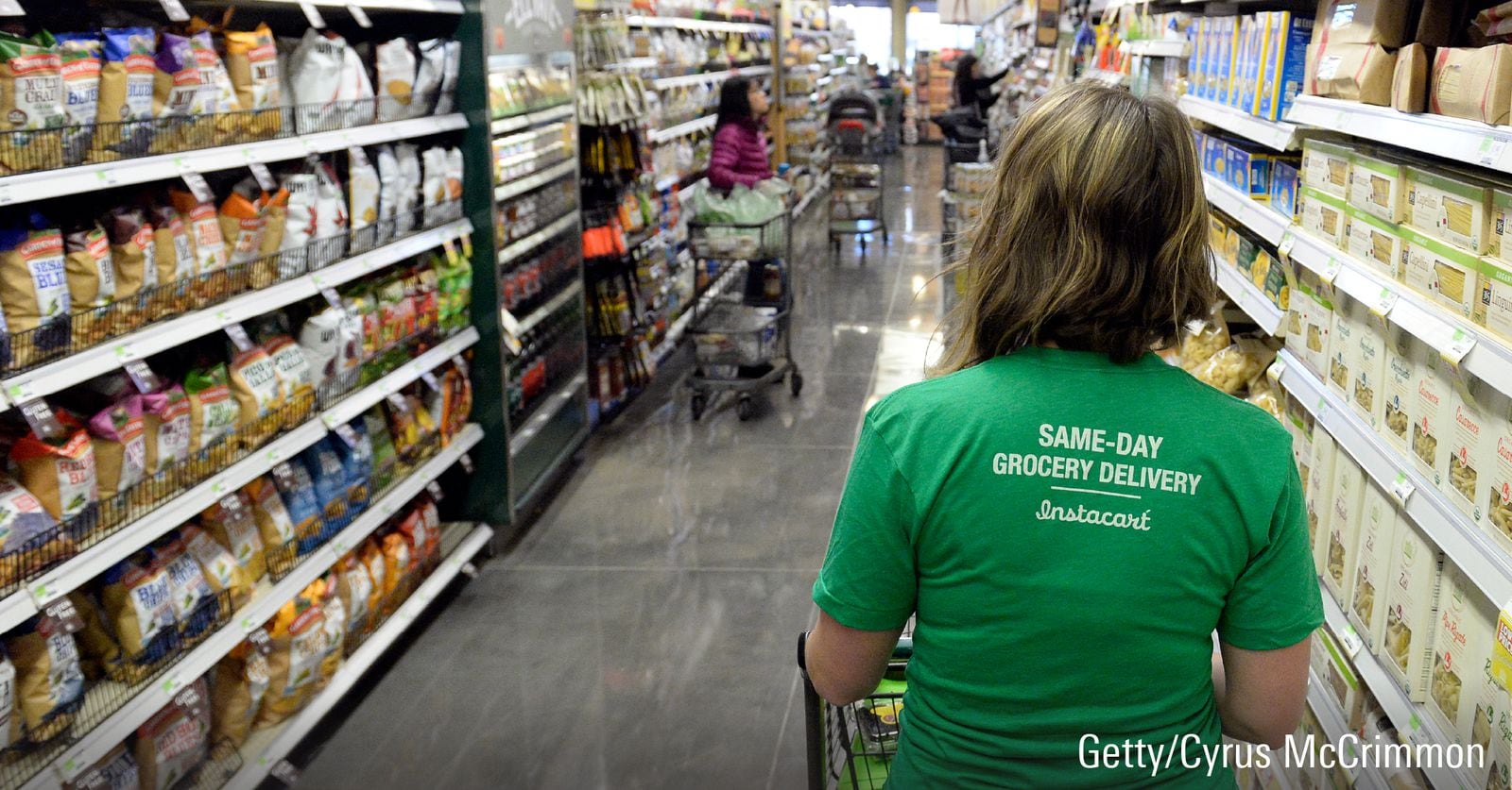 A woman shopping wearing an Instacart shirt