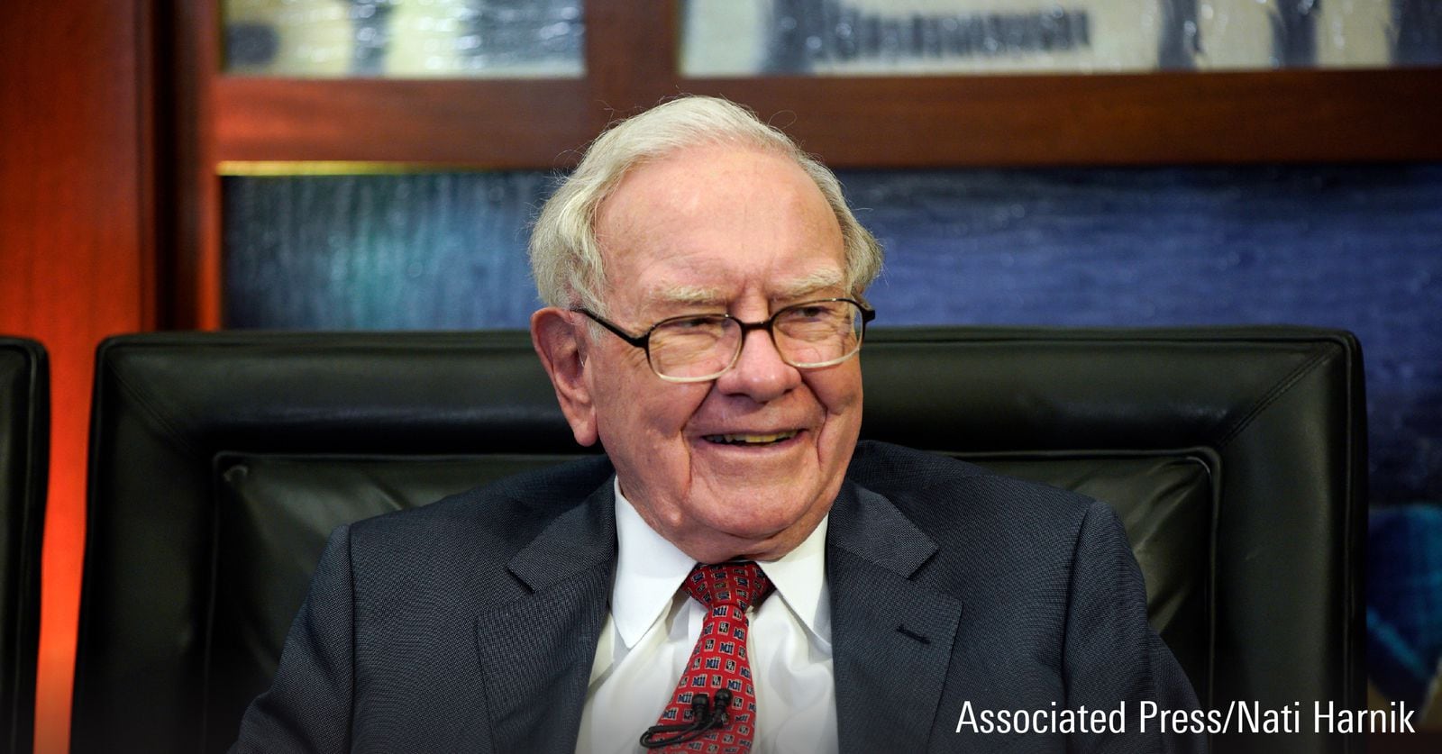 Et fotografi med Warren Buffett som snakker på et arrangement.